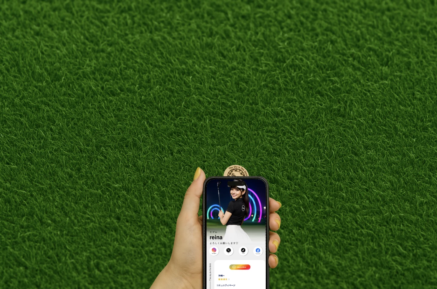 芝生の上でNFCマーカーにスマホをかざし、プロフィールを表示しているところ